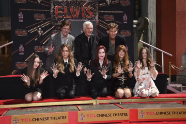 Jerry Schilling, former manger for Elvis Presley, from back row left, director Baz Luhrmann and actor Austin Butler, from the film "Elvis," look on as members of the Presley family, from front row left, Harper Presley Lockwood, Lisa Marie Presley, Priscilla Presley, Riley Keough and Finley Presley Lockwood show their hands after placing them in cement during a ceremony in their honor on Tuesday, June 21, 2022, at the TCL Chinese Theatre in Los Angeles.