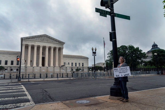 An abortion-rights activist stands outside the U.S. Supreme Court on June 23, which just struck down NY's gun laws.