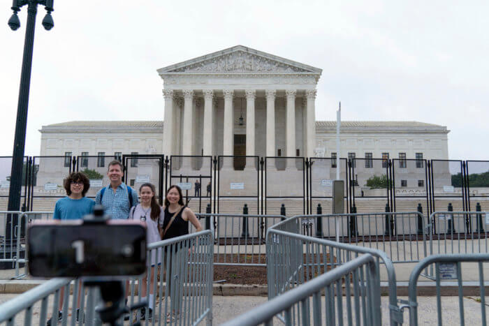 A family takes a selfie outside of the U.S. Supreme Court, which struck down the state's gun laws.