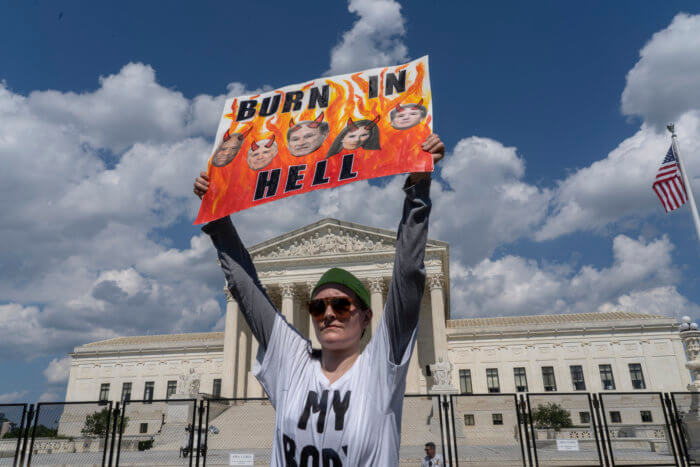 An abortion-rights protester displays a placard during a demonstration outside the Supreme Court in Washington, Saturday, June 25, 2022. The U.S. Supreme Court's decision to end constitutional protections for abortion has cleared the way for states to impose bans and restrictions on abortion — and will set off a series of legal battles. 