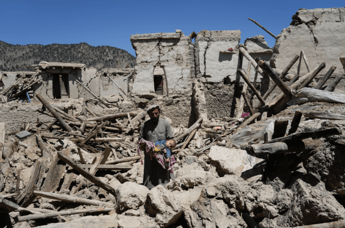 Afghan man carries his child amid destruction after an earthquake in Gayan village, in Paktika province, Afghanistan, Friday June 24, 2022. A powerful earthquake struck a rugged, mountainous region of eastern Afghanistan early Wednesday, flattening stone and mud-brick homes in the country's deadliest quake in two decades, the state-run news agency reported.