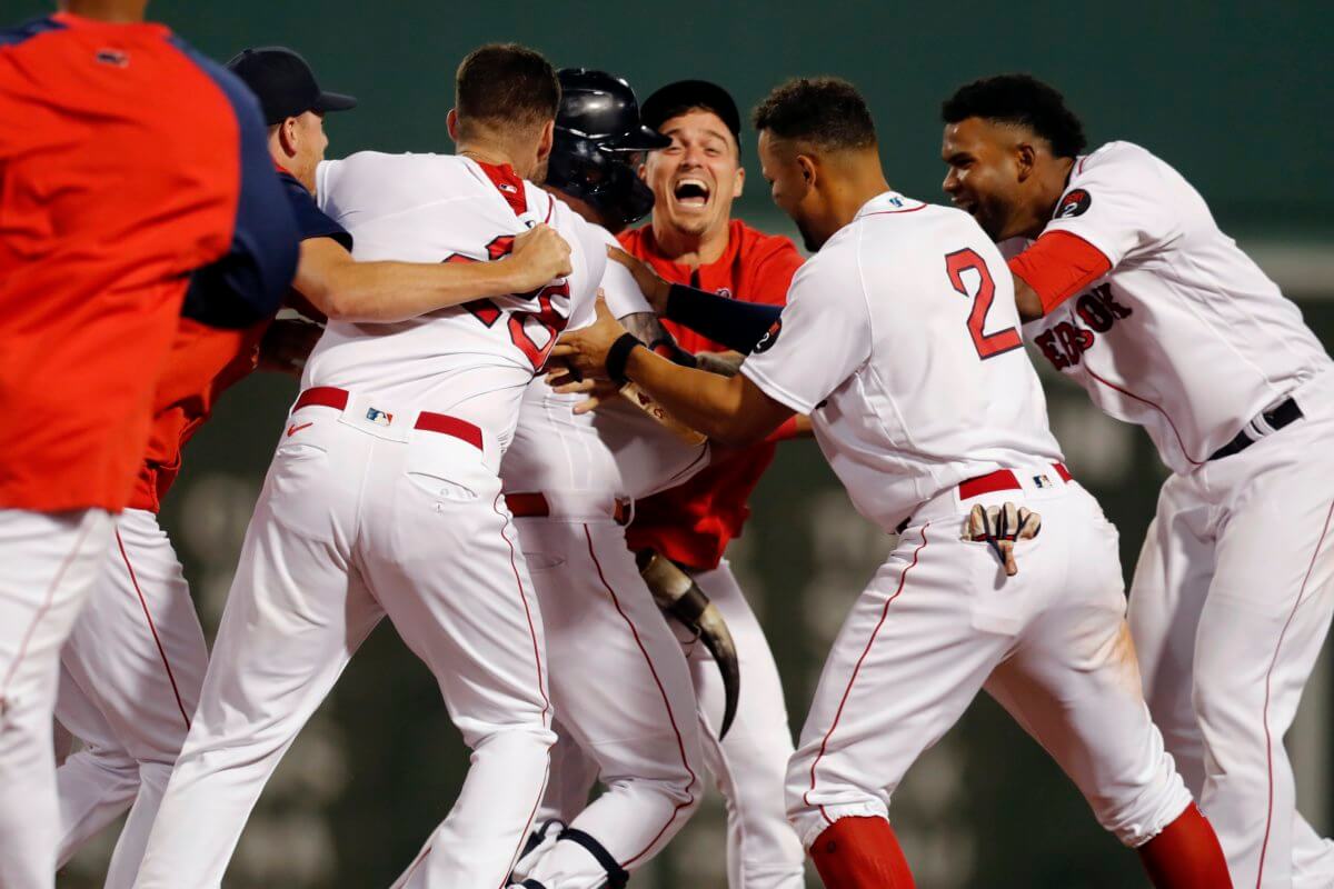 Boston Red Sox's J.D. Martinez (28), Xander Bogaerts (2) and teammates celebrate after Alex Verdugo, center left, hit a two-run single during the 10th inning to give the Red Sox a 6-5 win in a baseball game against the Alex Verdugo hit a tying single in the eighth inning and a winning two-run single that capped a three-run 10th, lifting the Boston Red Sox over the New York Yankees 6-5 Saturday night.