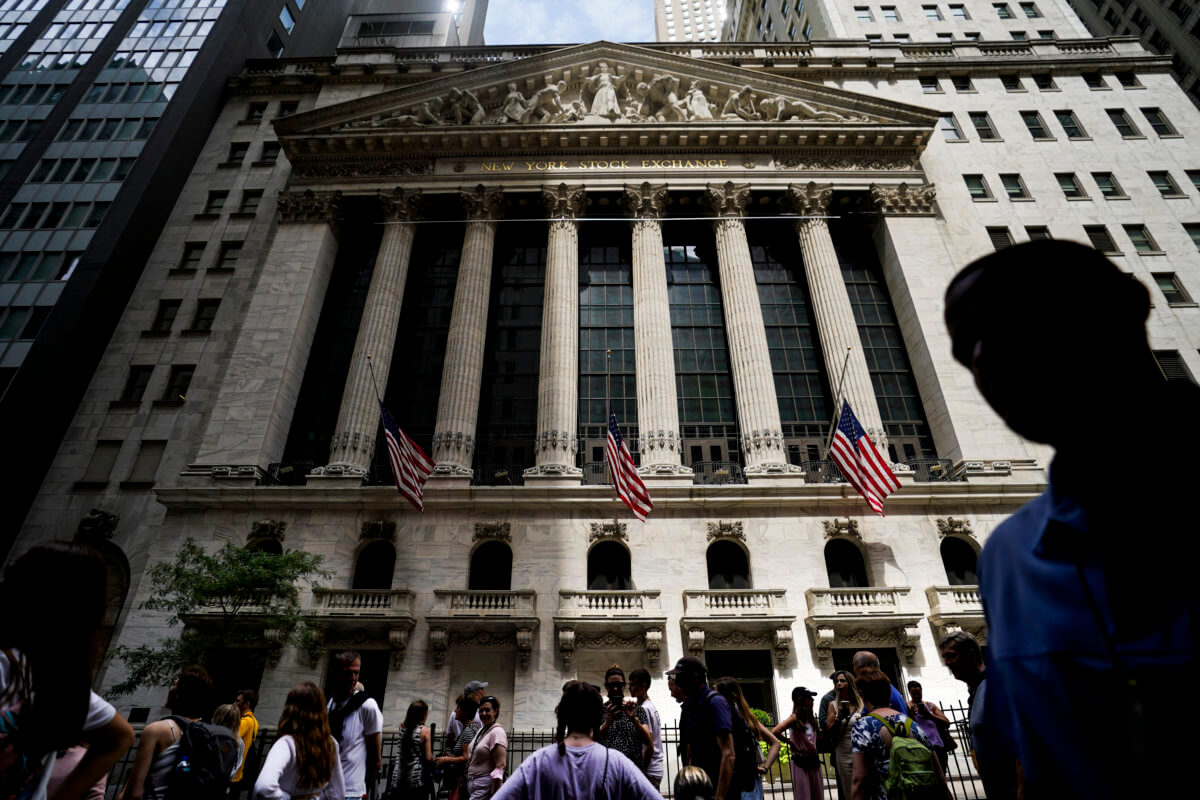 Pedestrians walk past the New York Stock Exchange.