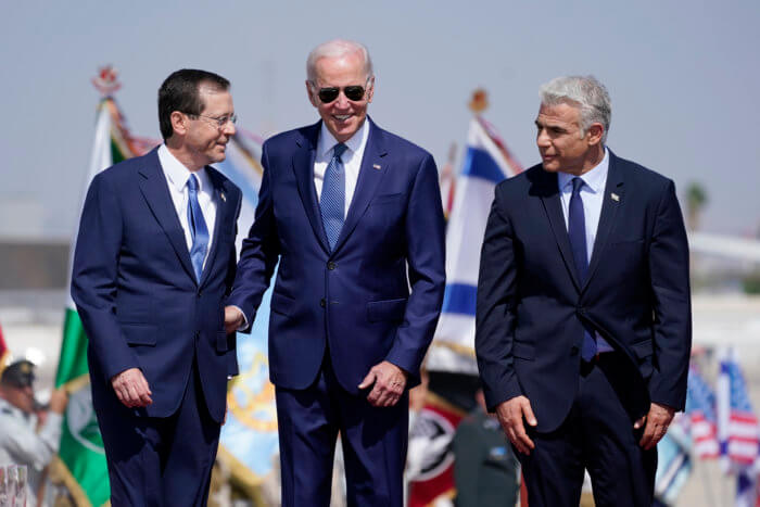 President Joe Biden stands with Israeli Prime Minister Yair Lapid, right, and President Isaac Herzog, left, after arriving at Ben Gurion Airport, Wednesday, July 13, 2022, in Tel Aviv.