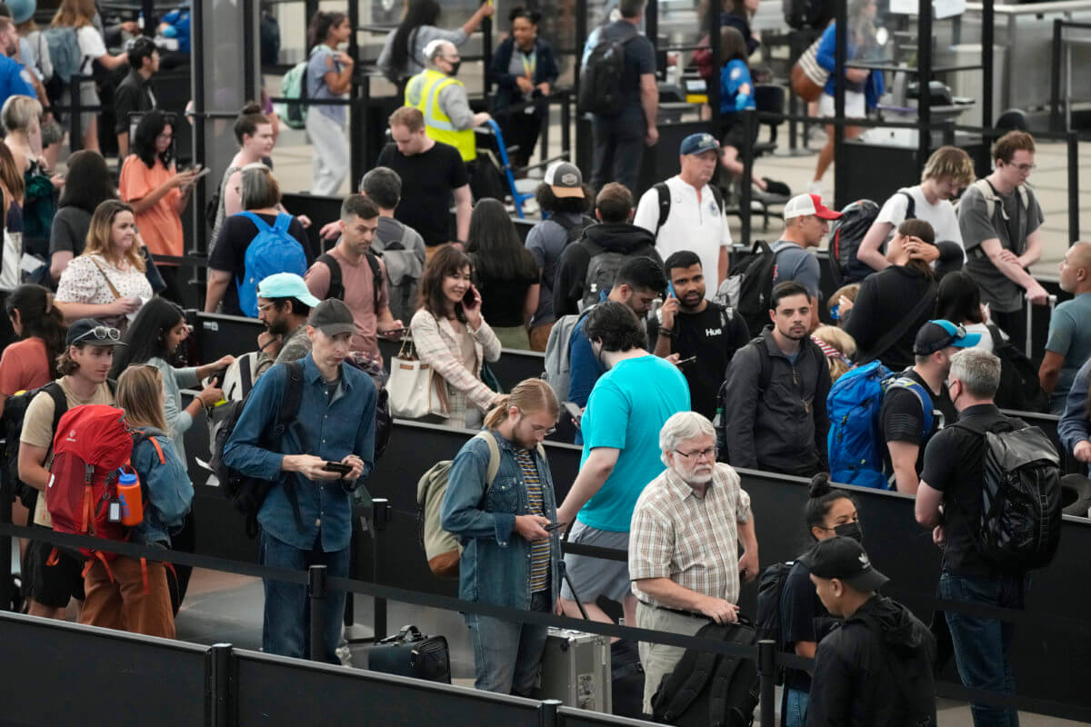 Travelers wait in long lines at a security checkpoint in Denver International Airport Tuesday, July 5, 2022, in Denver. The Fourth of July holiday weekend jammed U.S. airports with the biggest crowds since the pandemic began in 2020.