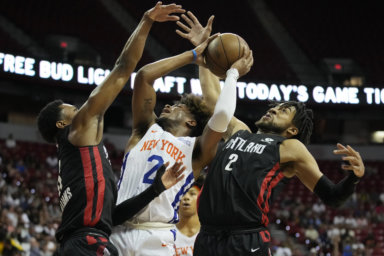Knicks' Miles McBride, center, attempts a shot against Trail Blazers' Brandon Williams, left, and Trendon Watford, right, during the first half the NBA summer league championship.