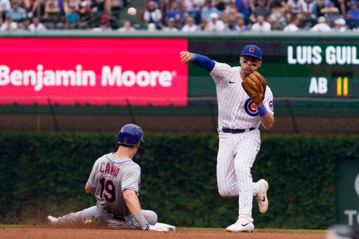 Cubs shortstop Nico Hoerner throws out Mets Luis Guillorme at 1st base after forcing out Mark Canha at 2nd during the 6th inning.