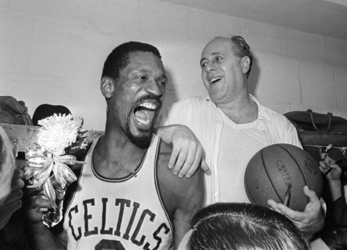 Celtics' Bill Russell, left, holds a corsage sent to the dressing room as he celebrates with Celtics coach Red Auerbach after they won their 8th-straight NBA Championship in 1966. 