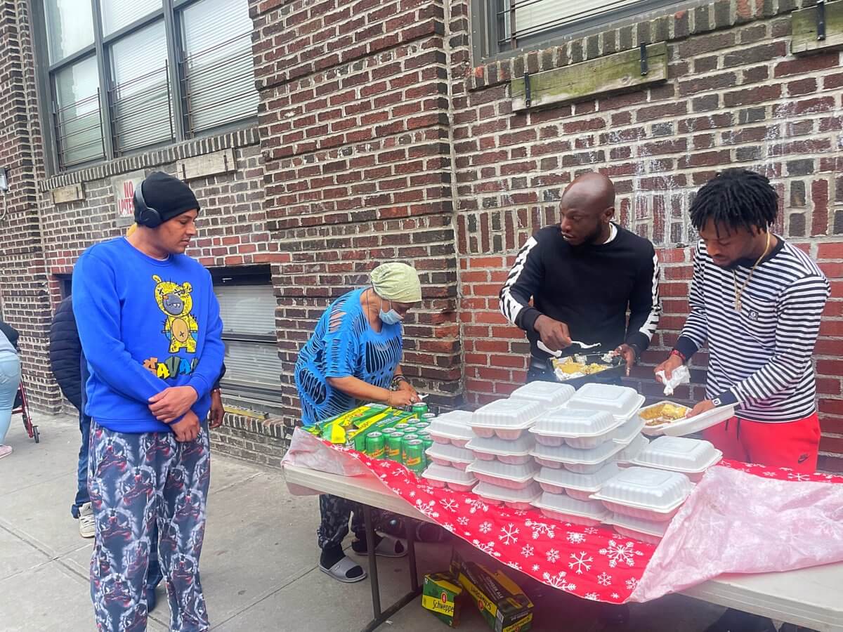 Community members line up for hot meals provided by Real World Ministries Inc.