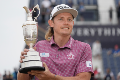 Cameron Smith, of Australia, holds the claret jug trophy as he poses for photographers on the 18th green after winning the British Open golf Championship