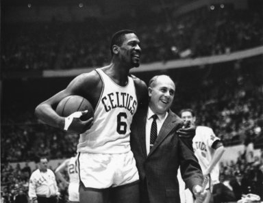Bill Russell, left, star of the Boston Celtics is congratulated by coach Arnold "Red" Auerbach after scoring his 10,000th point in the NBA game against the Baltimore Bullets in Boston Garden in 1964.