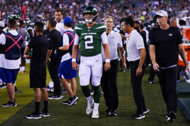 Jets' Zach Wilson walks on the sidelines after he is taken off the field following his injury.