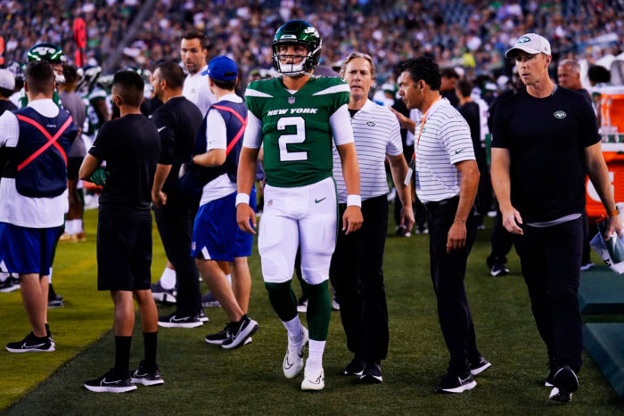 Jets' Zach Wilson walks on the sidelines after he is taken off the field following his injury.