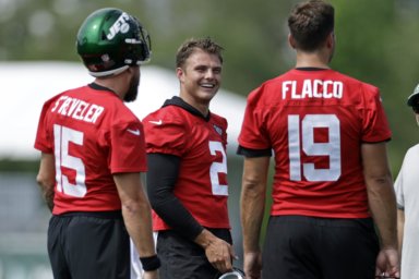 Jets quarterback Zach Wilson (2) laughs with quarterbacks Joe Flacco (19) and Chris Streveler during a break in drills