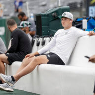 Jets quarterback Zach Wilson sits on the bench during practice while rehabbing his leg injury.