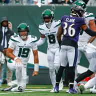 Jets' Elijah Moore helps up quarterback Joe Flacco after Flacco threw an interception during the first half against the Ravens.
