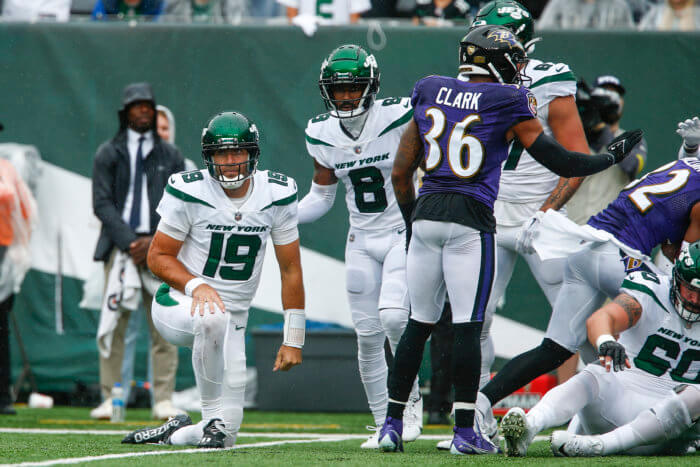 Jets' Elijah Moore helps up quarterback Joe Flacco after Flacco threw an interception during the first half against the Ravens.