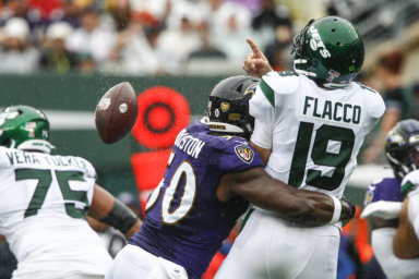 Ravens' Justin Houston hits Jets quarterback Joe Flacco as he throws a pass during the first half of their Week 1 matchup.