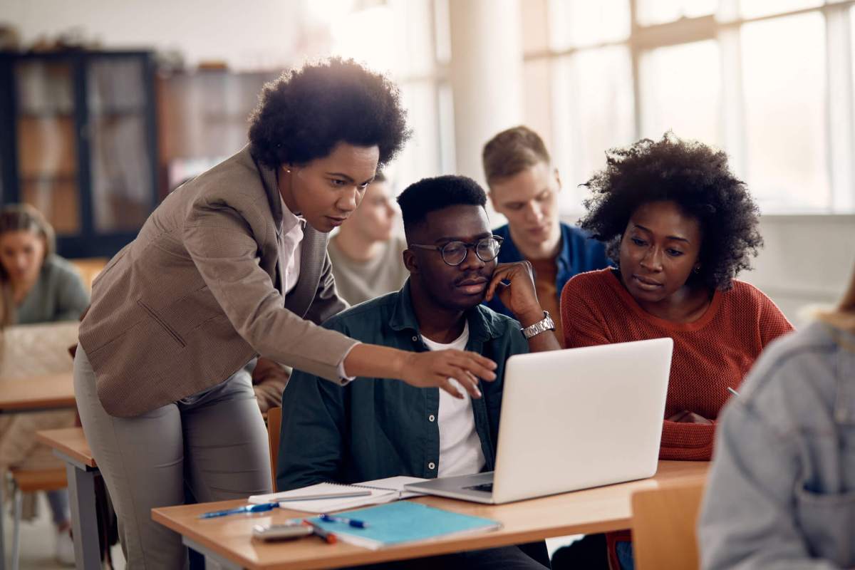 African Americans college students e-leaning with their teacher during a class.