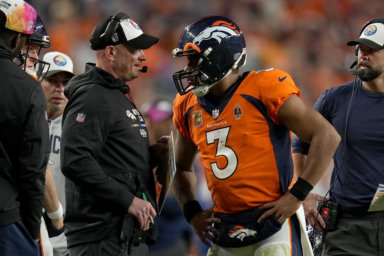 Broncos quarterback Russell Wilson, who will sit against the Jets, talks with head coach Nathaniel Hackett.