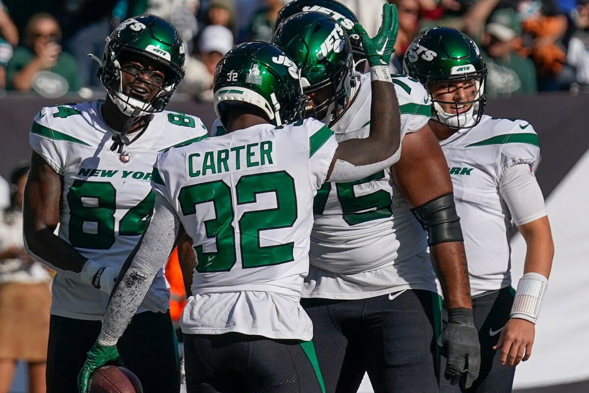 NFL - Jets running back Michael Carter (32) celebrates with teammates after scoring a touchdown against the Miami Dolphins.