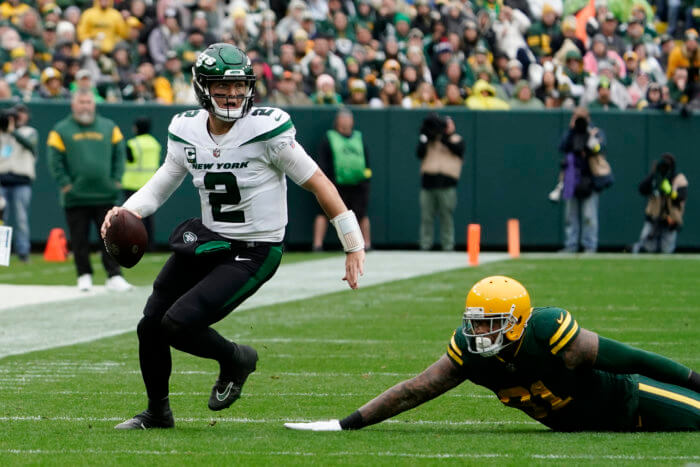 Jets quarterback Zach Wilson scrambles past Green Bay Packers linebacker Preston Smith in Week 6.