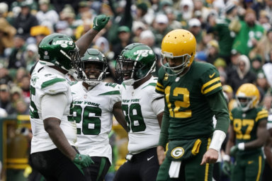 Jets defensive end John Franklin-Myers, left, celebrates with teammates after sacking Green Bay Packers quarterback Aaron Rodgers.