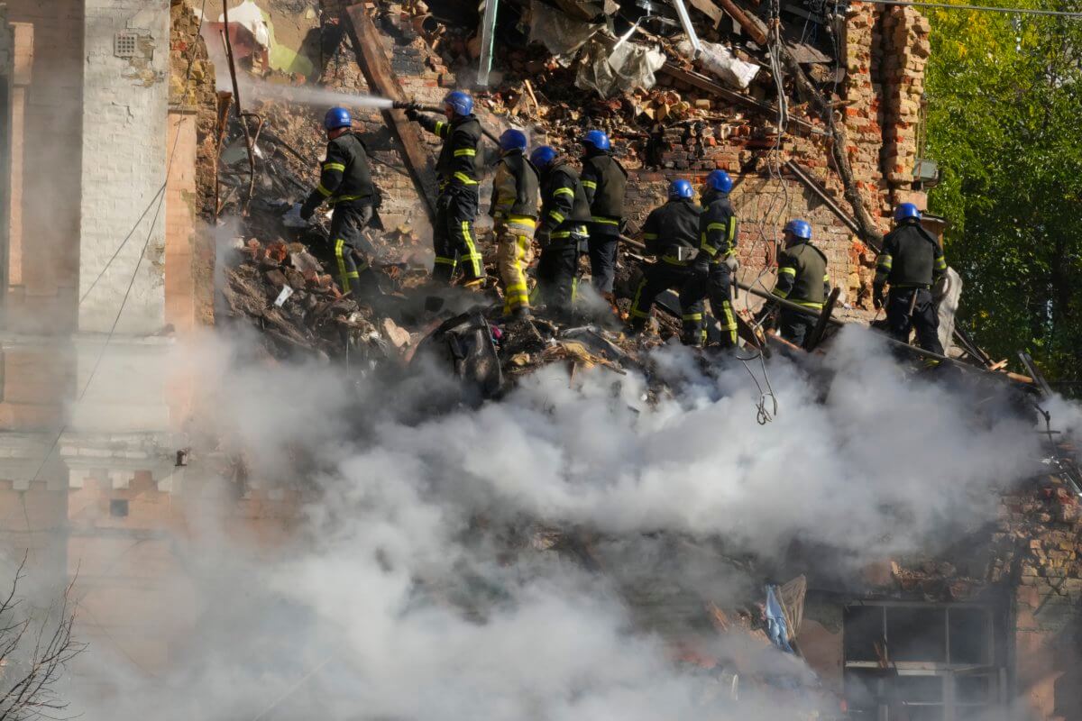 Firefighters try to extinguish a fire after a drone fired at buildings in Kyiv, Ukraine