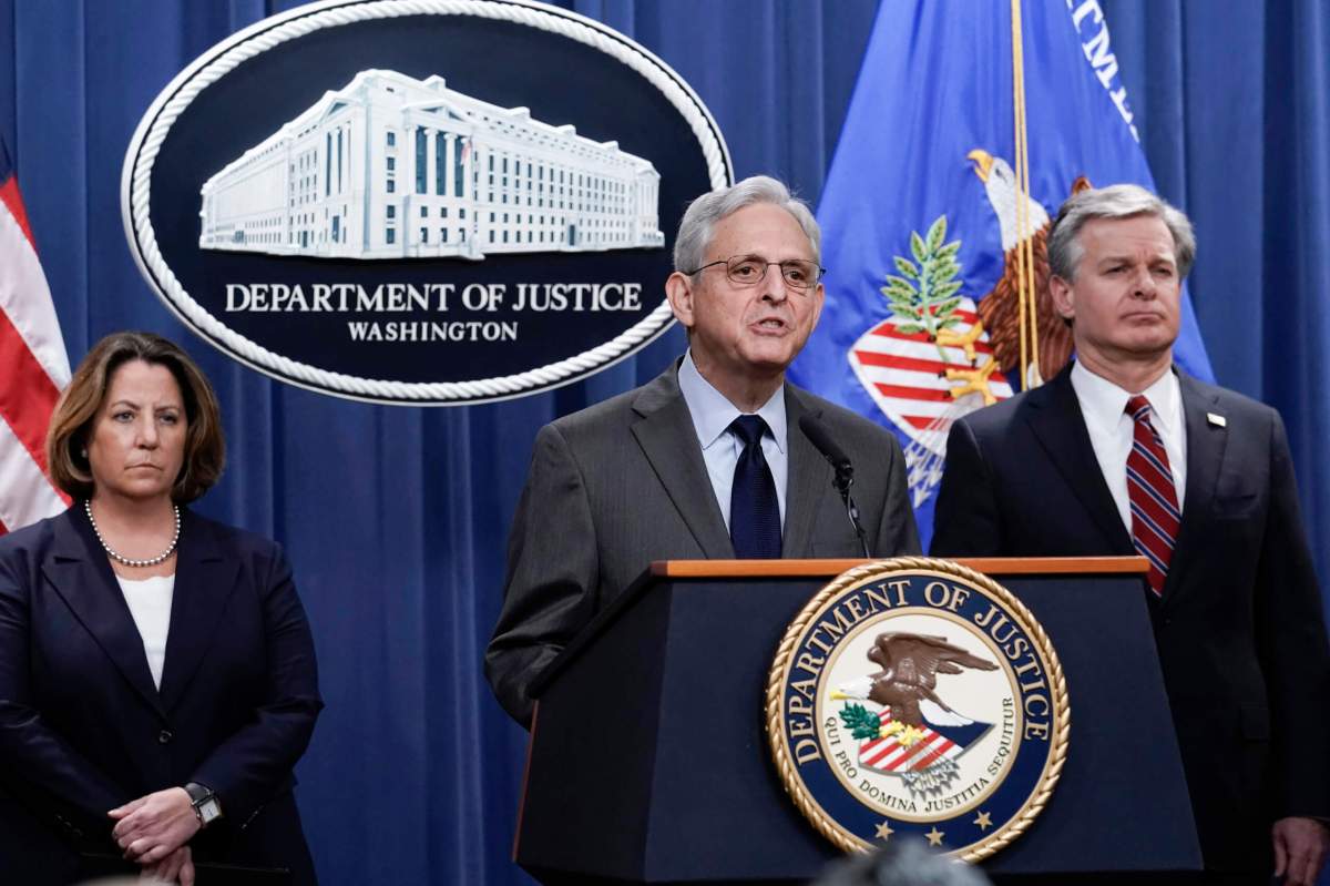 Attorney General Merrick Garland, center, flanked by Deputy Attorney General Lisa Monaco, left, and FBI Director Christopher Wray, speaks to reporters as they announce charges against two men suspected of being Chinese intelligence officers for attempting to obstruct a U.S. criminal investigation and prosecution of Chinese tech giant Huawei, at the Department of Justice in Washington, Monday, Oct. 23, 2022.