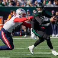 New York Jets quarterback Zach Wilson avoids a tackle from New England Patriots linebacker Matthew Judon.