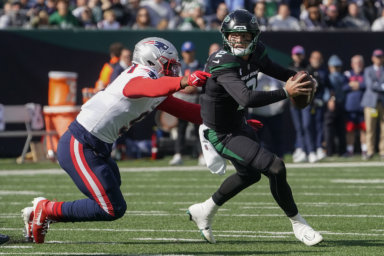 New York Jets quarterback Zach Wilson avoids a tackle from New England Patriots linebacker Matthew Judon.