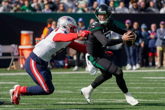 New York Jets quarterback Zach Wilson avoids a tackle from New England Patriots linebacker Matthew Judon.