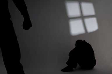 Shadow of a person in the corner hiding from abuse