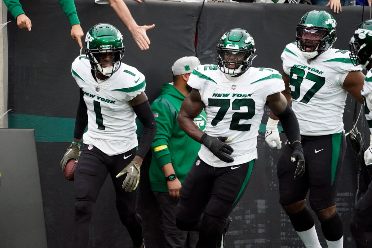 Jets cornerback Sauce Gardner (1) celebrates with teammates Micheal Clemons (72) and Nathan Shepherd (97).