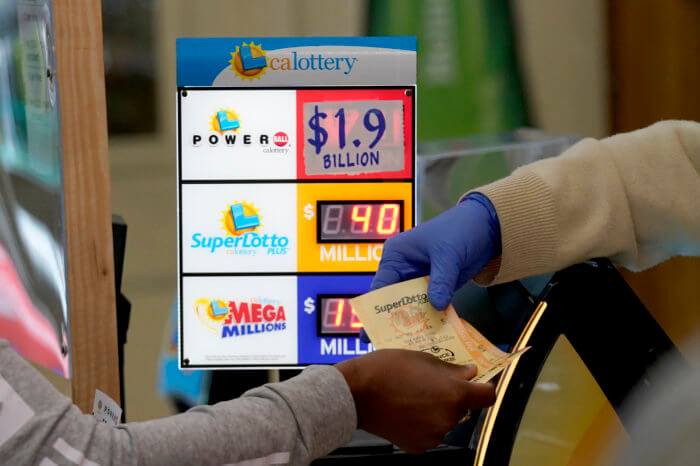 A customer is handed Powerball tickets.