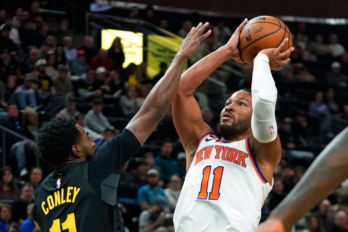 Knicks guard Jalen Brunson shoots as Utah Jazz guard Mike Conley defends.