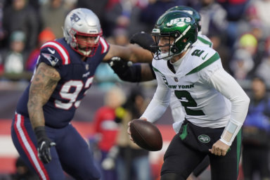 Jets quarterback Zach Wilson runs under pressure from New England Patriots defensive end Lawrence Guy.