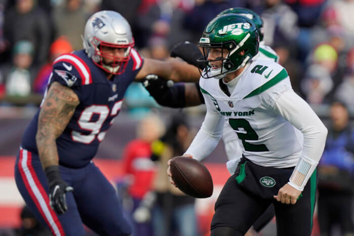 Jets quarterback Zach Wilson runs under pressure from New England Patriots defensive end Lawrence Guy.