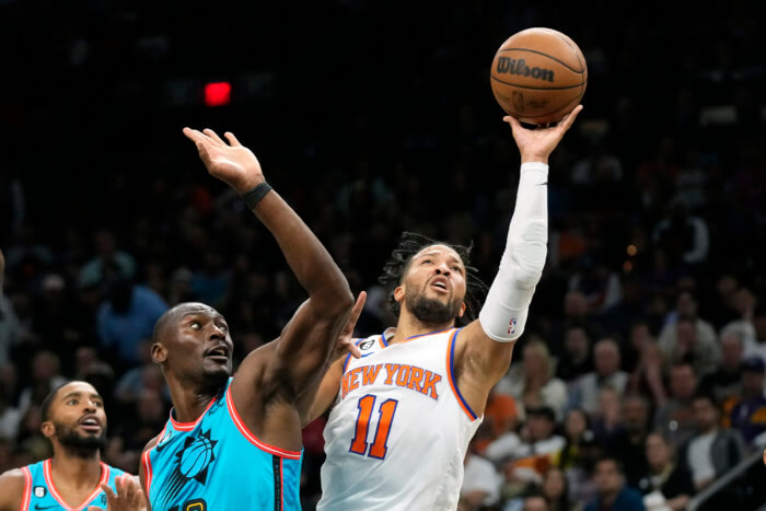 Knicks guard Jalen Brunson drives past Suns center Bismack Biyombo, center, and forward Mikal Bridges.