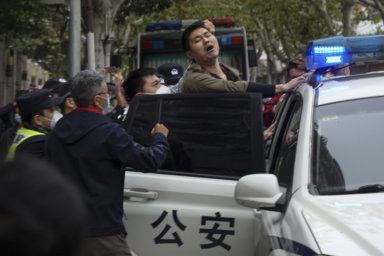A protester reacts as he is arrested by policemen during a protest on a street in Shanghai, China. Authorities eased anti-virus rules in scattered areas but affirmed China's severe "zero- COVID" strategy Monday after crowds demanded President Xi Jinping resign during protests against controls that confine millions of people to their homes.