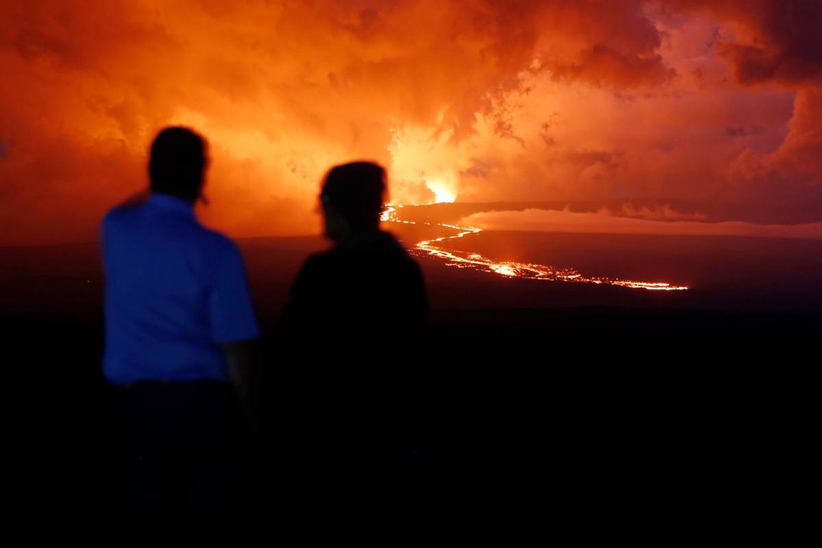 Spectators watch the lava flow down the mountain from the Mauna Loa eruption in Hawaii