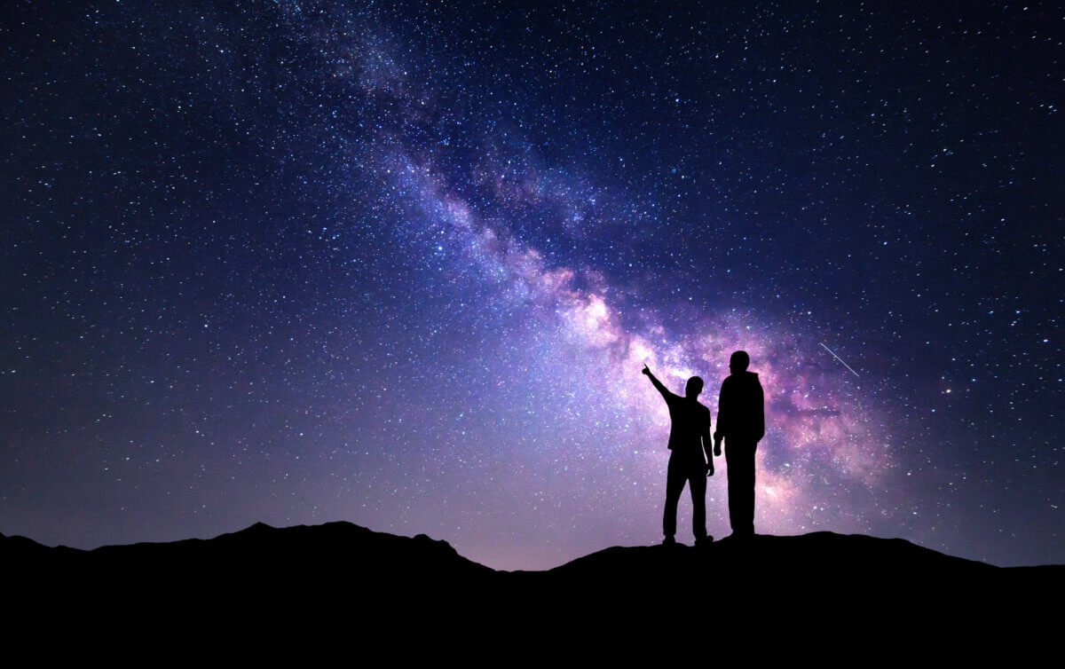 Landscape with Milky Way. Silhouette of a father and son