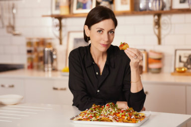 Mary McCartney posing with handful of nachos, as seen on "Mary McCartney Serves It Up"