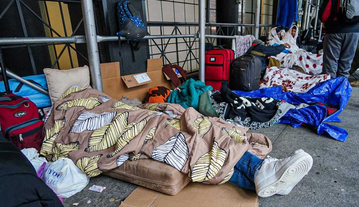 Asylum seekers sleep outside of the Watson Hotel