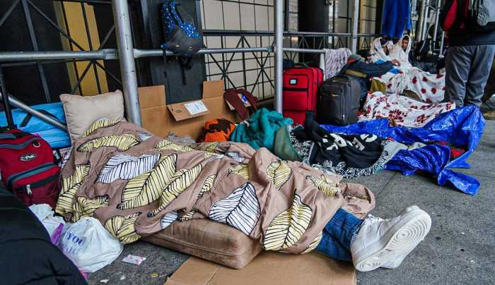 Asylum seekers sleep outside of the Watson Hotel