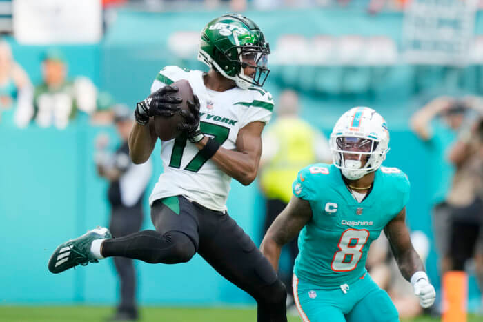 Jets wide receiver Garrett Wilson grabs a pass in front of Dolphins safety Jevon Holland.