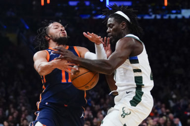 Knicks Jalen Brunson is fouled by Jrue Holiday
