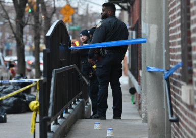 An officer stands near a crime scene where a teen was shot in Brooklyn.