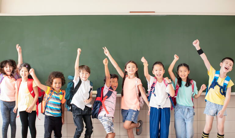 Group of diverse young students standing together in classroom