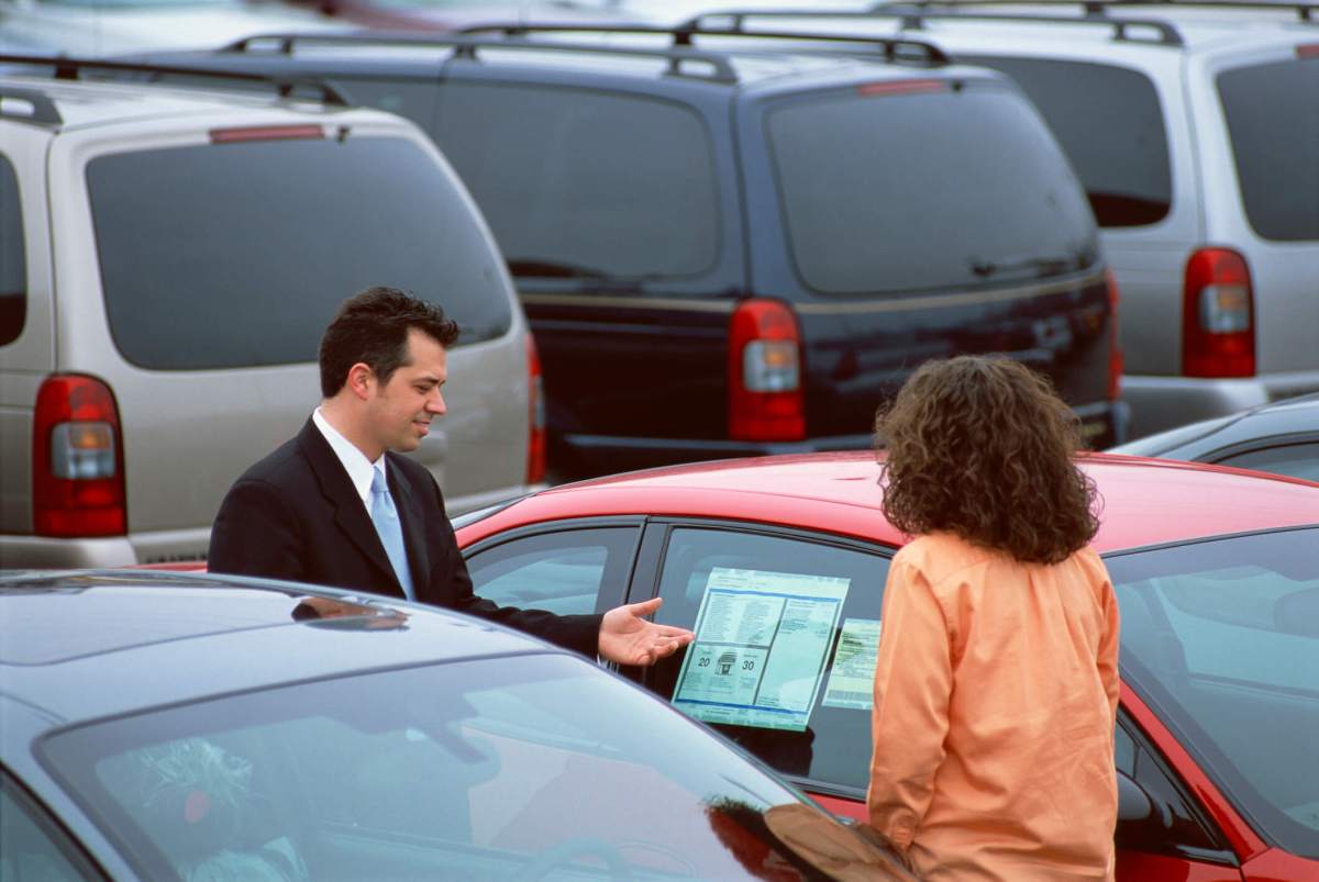 Man showing woman a car for sale